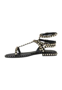 Zwarte platte sandalen met ronde gouden studs langs de banden, enkelbandjes en zool. Sleehak met een gladde textuur.