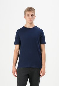 T-shirt en jersey bleu marine à manches courtes en tissu doux, avec un col rond classique et une coupe régulière. Design simple sans motifs visibles.