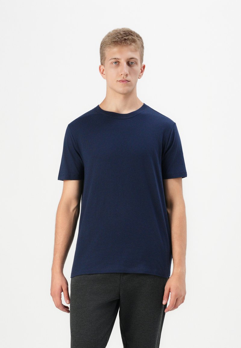 T-shirt en jersey bleu marine à manches courtes en tissu doux, avec un col rond classique et une coupe régulière. Design simple sans motifs visibles.