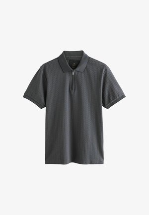 Polo grigio con un motivo testurizzato che ricorda l'ordine a spina di pesce, maniche corte e colletto con zip. Il materiale sembra leggero e traspirante.