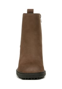 Bottine marron avec une texture en daim lisse, une silhouette élancée, un col rembourré et une semelle en caoutchouc avec un profil texturé pour une meilleure adhérence.