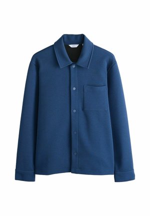 Zils teksturēts krekla jaka ar garām piedurknēm, priekšējā kabata, pogu aizdare un smailām apkaklēm.