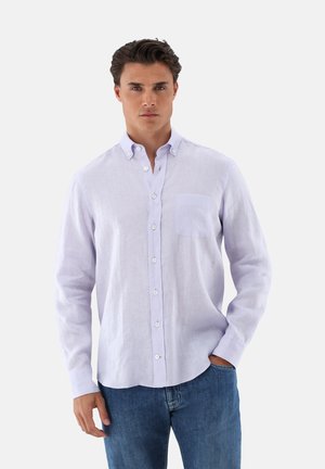 Helles lila Langarmhemd aus Leinen mit Button-Down-Kragen und einer einzelnen Brusttasche, kombiniert mit blauen Jeans.