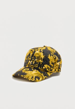Črna in rumena baseball kapa z baročnim vzorcem, z vezenim napisom "Versace Jeans Couture" v črni barvi na sprednji plošči.