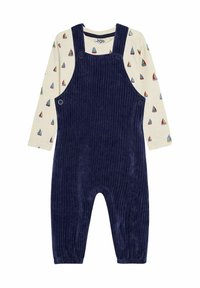 Marineblaue Corduroy-Latzhosen mit verstellbaren Trägern, Seitenschbuttons und elastischen Bündchen, kombiniert mit einem cremefarbenen Langarmshirt mit Segelboot-Muster.