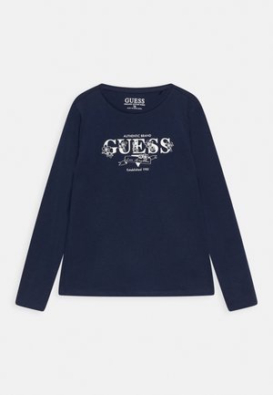 Marineblauw shirt met lange mouwen en wit bloemenlogo met de tekst "GUESS Los Angeles Established 1981" gecentreerd op de voorkant.