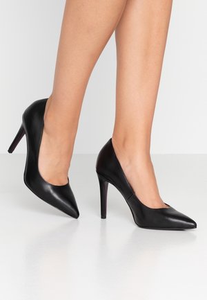 Zwarte leren hoge hakken met een puntige neus, een gladde textuur en een slanke uitstraling. Voorzien van een stilettohak voor extra hoogte.