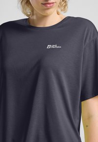 Marineblauwe T-shirt met korte mouwen, gemaakt van zachte stof en met een relaxte pasvorm. Voorzien van een klein wit logo op de borst. Soepele textuur.