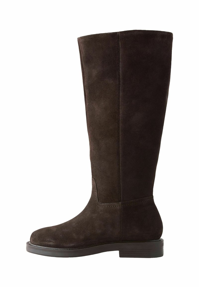 Cizmă înaltă până la genunchi din suede maro închis, cu o textură netedă, vârf rotund, toc plat și detalii cu cusături pe lateral. Design simplu.