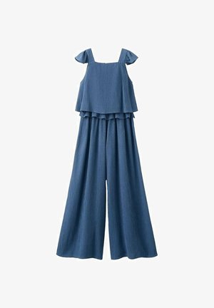 Sininen hihaton haalari, jossa leveät lahkeet ja röyhelöyksityiskohdat olkaimissa ja vyötärön alueella.