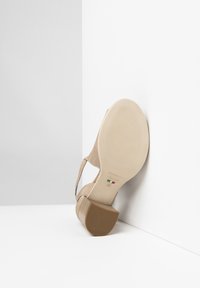 Chaussure à talon aiguille beige avec une tige en tissu texturé, un talon effilé, et une semelle lisse portant un logo et la mention taille 37.