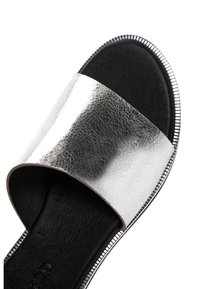 Zilveren leren slip-on sandaal met een brede band, gestructureerde bovenkant, zwarte voetbed en metallic zilveren rand rondom de zool.