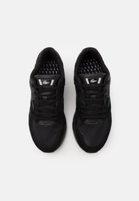 Schwarze Sportschuhe mit Obermaterial aus Mesh und Synthetik, Schnürdesign, gepolsterter Sohle und gemustertem Innenfutter.