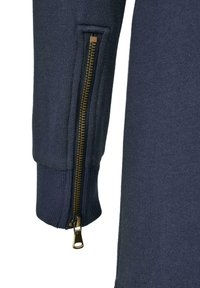 Pull marin avec des poignets côtelés et une fermeture éclair dorée apparente sur la manche gauche. Textile doux avec une texture lisse.