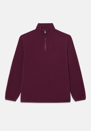 Maroon fleece pullover with a high collar, half-zip closure, long sleeves, and a subtle logo in the upper center. Soft, smooth texture.