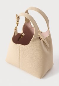 Τσάντα από μπεζ δέρμα με υφή, δύο χερούλια, χρυσό κούμπωμα και εσωτερική επένδυση απαλού ροζ χρώματος, εμφανίζεται ανοιχτή σε απλό φόντο.