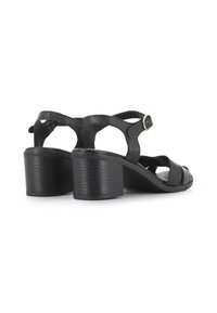 Sandalias negras de cuero con un tacón grueso y correas estrechas. Cuentan con un hebilla en el tobillo y un diseño recortado. Textura suave.