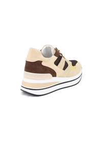 Sneaker beige e marrone con pannelli in rete, camoscio testurizzato e una suola spessa e bianca con accenti neri e una leggera elevazione.