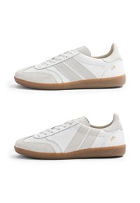 Deux baskets basses blanches avec semelles en gomme naturelle, bouts en daim et fines bandes beiges, affichées en vue latérale sur fond blanc.
