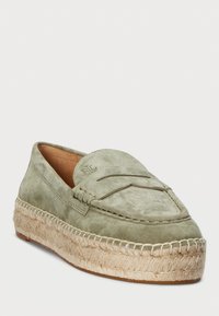 Zaļi zamšāda loafers ar teksturētu apdari un auzu zoli. Iespējo iet cors muguras un izcelta zīmola identifikācija.