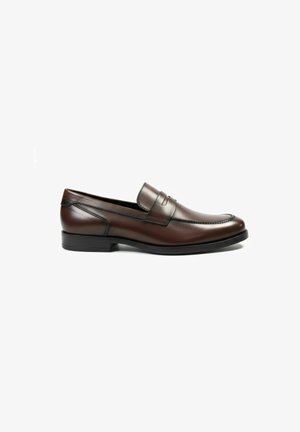 Mocassino slip-on in pelle marrone con tacco basso, punta arrotondata e dettaglio a fascia decorativa sul lato, su sfondo bianco.
