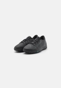 Black athletic shoes made of textured synthetic material. Features a curved shape, lace-up design, and a teal accent on the sole.
