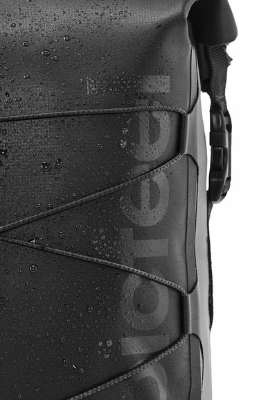 Bolsa impermeable negra con una superficie texturizada, que presenta gotas de agua, correas elásticas y un broche lateral para el cierre.