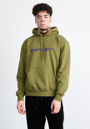Sudadera verde oliva hecha de tela suave, con un bolsillo frontal y el logo "carhartt." en color púrpura, con puños y dobladillo acanalados.