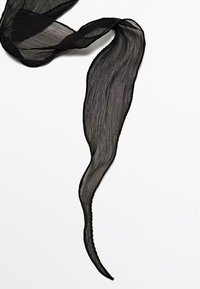 Écharpe plissée noire avec une texture lisse et légère, d'une forme ondulée, présentant des détails complexes le long des bords.