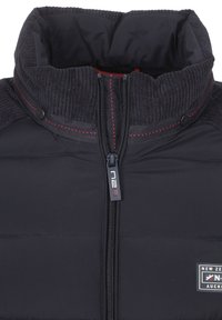 Donkere donsjacket met een hoge kraag, geribbelde stofaccenten, contrasterende rode stiksel en een voorkant met rits voorzien van een logo-trekker.