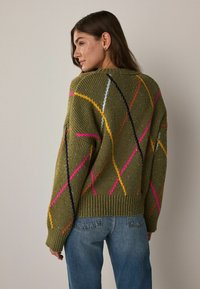 Olive green knit sweater featuring colorful diamond patterns in pink, yellow, and black. Ribbed cuffs and hem, medium thickness texture.