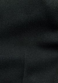 Mustast kangast, millel on tekstuuriga koemuster. Materjal tundub tugev ja tihe, iseloomustatud ühtlase pinnaga, millel on peened varjundivariatsioonid.