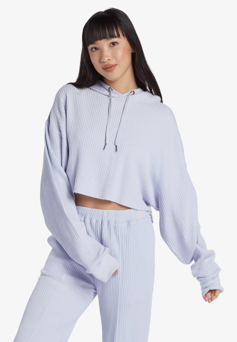 Helleblaue, kurze Kapuzenjacke aus strukturiertem Waffelstrick mit Kordelzugkapuze. Kombiniert mit passenden strukturierten Jogginghosen.