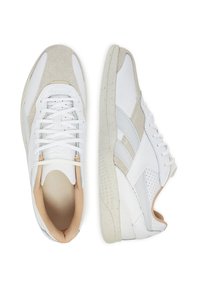 Baltos kedai su sportu su tekstūruota kreminės spalvos zomšo nosimi, lygių odinių intarpų, raištelių užsegimu priekyje ir smėlio spalvos vidine pamušala. Tekstūruota pado akcentai.