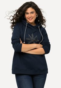 Námořnická mikina s cowl krkem, provázkovými šňůrkami a dekorativním designem sněhové vločky z kamínků na přední straně. Pohodlný střih, smíšená bavlna.