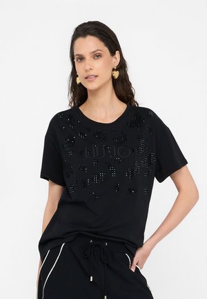T-shirt nera a maniche corte con un design testurizzato, logo in rilievo e lucido, arricchita con paillettes sparse.
