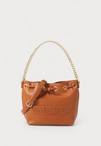 Borsa a secchiello in pelle marrone con manico e tracolla in catena dorata, con logo impresso e chiusura a coulisse. Texture liscia, forma compatta.