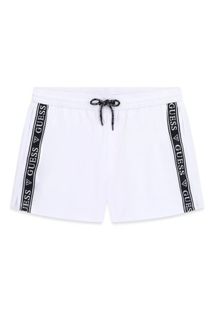 White men's swim shorts with black drawstring and black side stripes featuring repeated "GUESS" logos.