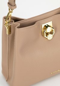 Borsa a tracolla in pelle beige con superficie texturizzata, dotata di chiusura e accessori in tonalità oro, e un design strutturato.