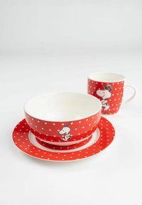 Red ceramic bowl with white polka dots and a Snoopy illustration, paired with a matching red cup and a round plate. Smooth, glossy surface.