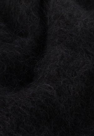 Lähivaade pehmest mustast udusarnase kangast, millel on peened, sõlme läinud kiud, mis loovad tekstuurse pinna ja peened valgusvarjud.