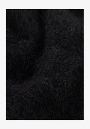 Lähivaade pehmest mustast udusarnase kangast, millel on peened, sõlme läinud kiud, mis loovad tekstuurse pinna ja peened valgusvarjud.