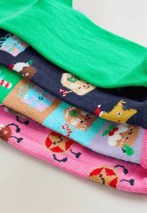 Vier Paare gemusterte Socken: Ein einfarbig grünes Paar oben, gefolgt von marineblauen Socken mit Feiertagsmotiven und rosa Socken mit Lebkuchenmotiven.