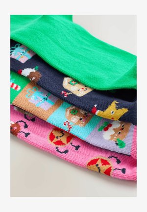 Vier Paare gemusterte Socken: Ein einfarbig grünes Paar oben, gefolgt von marineblauen Socken mit Feiertagsmotiven und rosa Socken mit Lebkuchenmotiven.