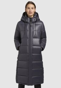 Cămașă lungă căptușită de culoare bleumarin închis, cu fermoar la front, glugă ajustabilă și design matlasat orizontal. Fabricată din material lucios și rezistent la apă.
