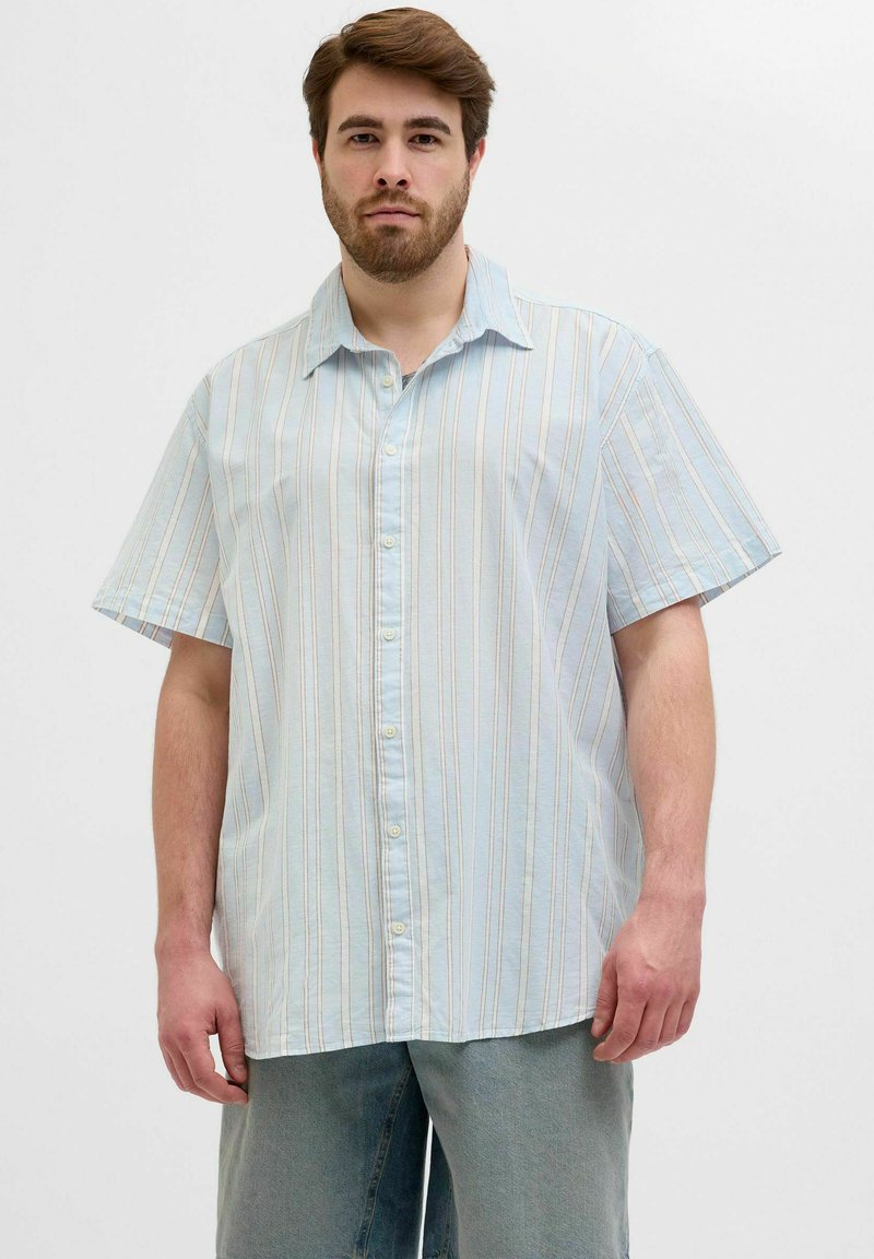 Camisa de botones de manga corta en azul claro con rayas verticales en colores pastel; presenta un cuello spread y una tela suave y texturizada.