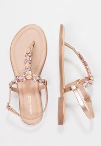 Flat sandals with a metallic rose gold color, featuring a bejeweled strap of clear and light pink stones. Slim ankle strap included.