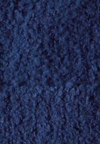 Tessuto blu navy con una superficie morbida e pelosa, caratterizzato da fibre arricciate che creano un aspetto soffice.