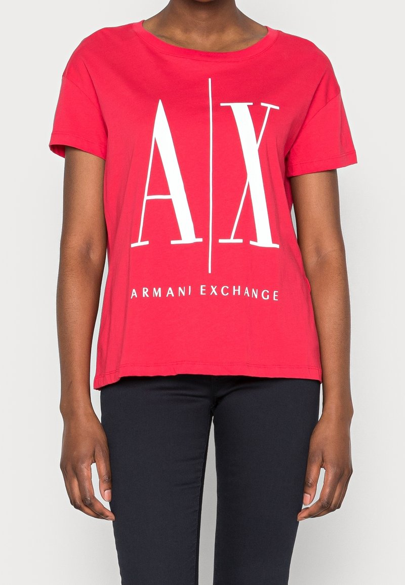 Czerwona bawełniana koszulka z krótkim rękawem, z dużymi białymi nadrukowanymi literami "A X" oraz napisem "ARMANI EXCHANGE" poniżej. Luźny krój.