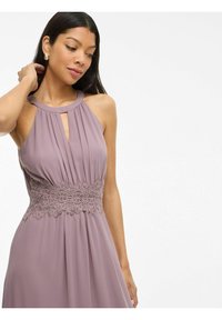 Robe mauve à encolure halter avec des plis et une ceinture en dentelle. Texture lisse avec un détail en forme de trou de serrure au niveau du décolleté.